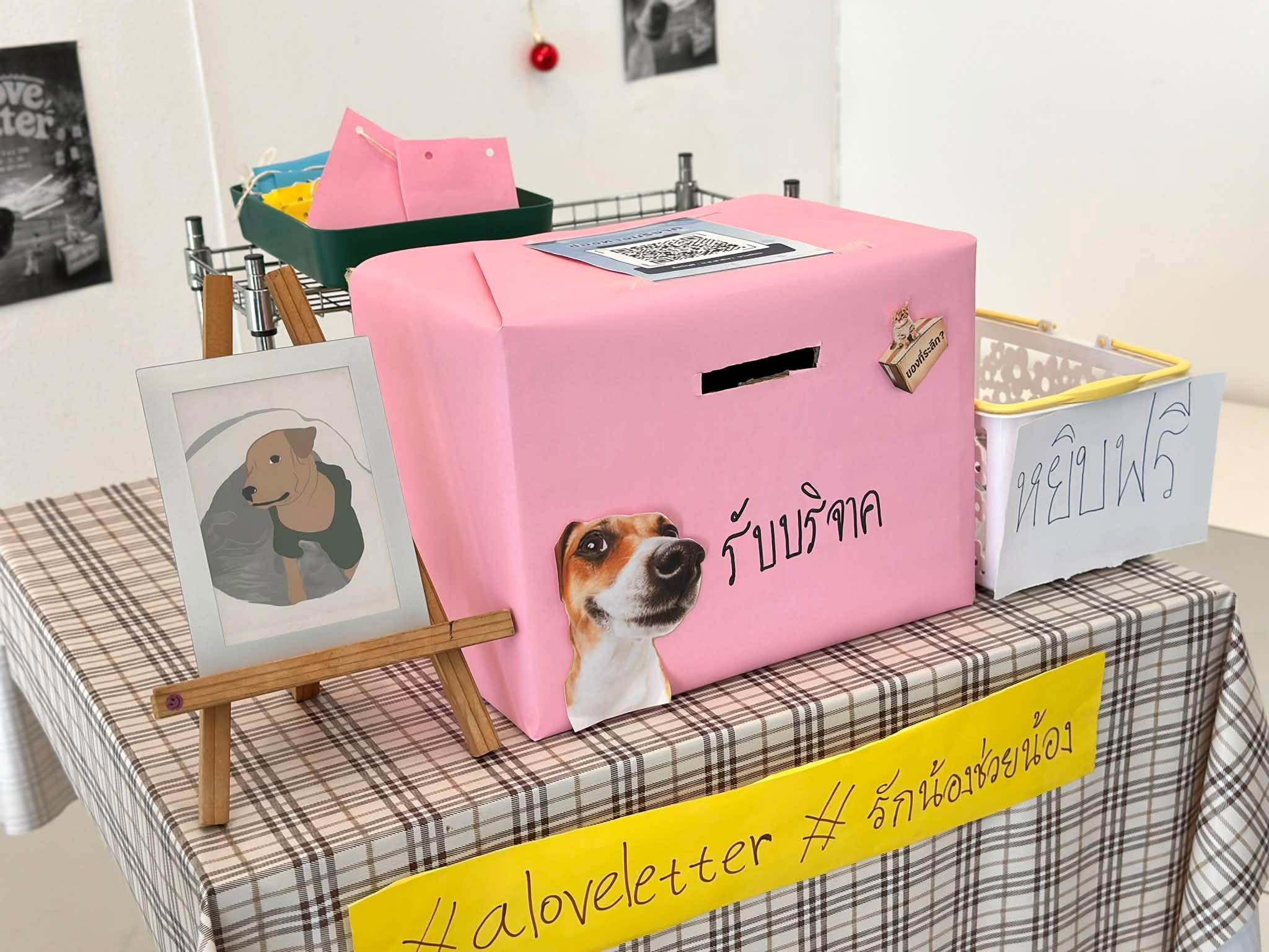 มุมจัดแสดง A Love Letter พร้อมกล่องรับบริจาคสีชมพู