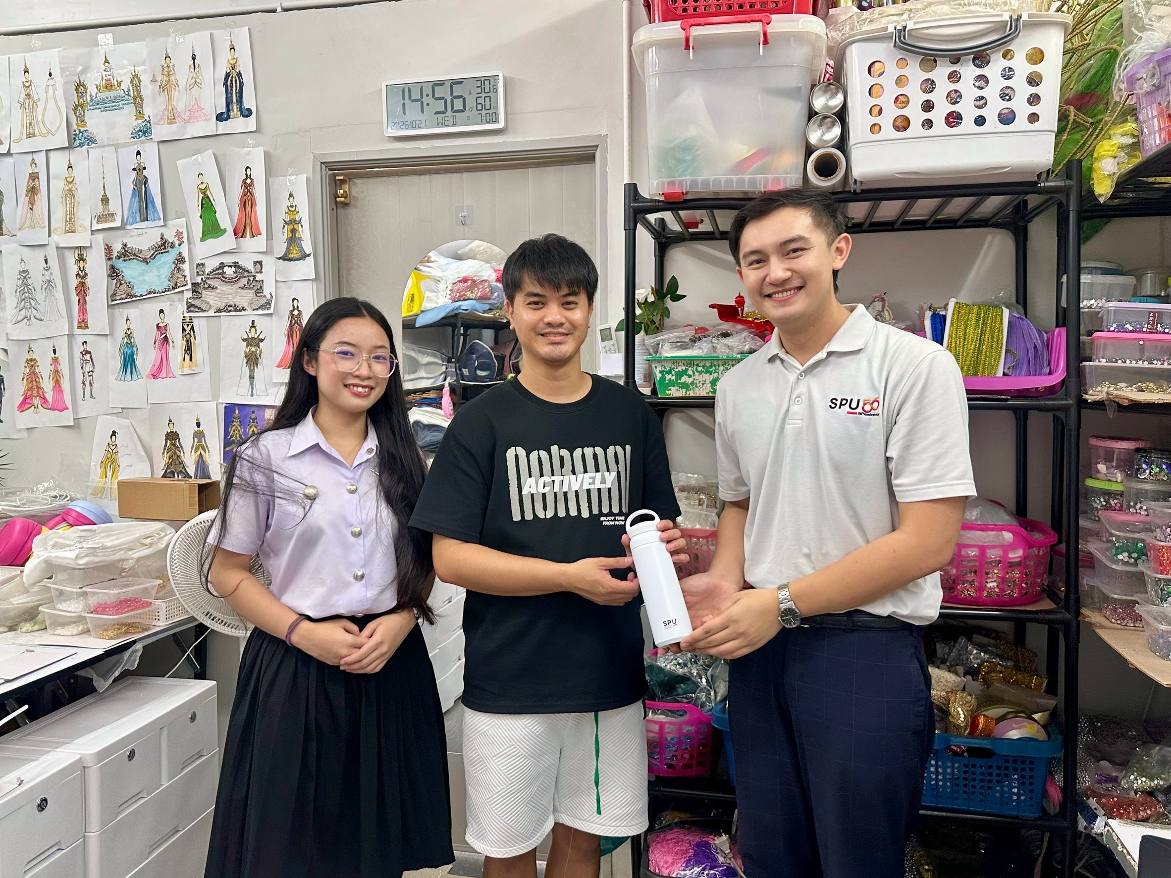 ภาพร่วมกันภายในห้องเสื้อซึ่งมีแบบเครื่องแต่งกายและอุปกรณ์ทำงาน